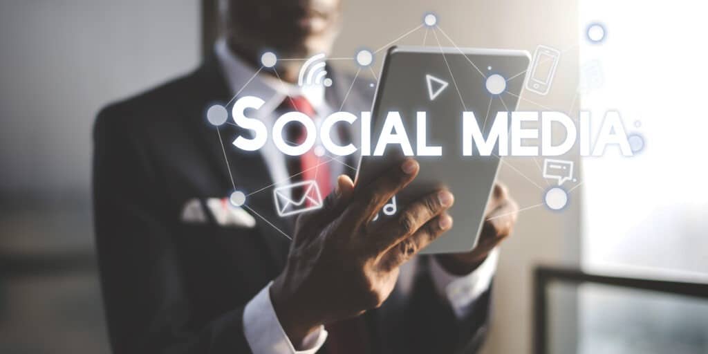 Hand holding smartphone with social media marketing icons and engagement symbols floating above